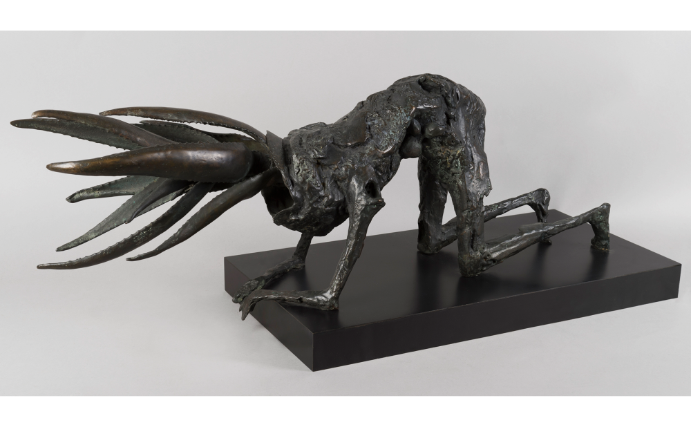 Bronze sculpture of a humanoid figure with plant-like head in a crawling position.