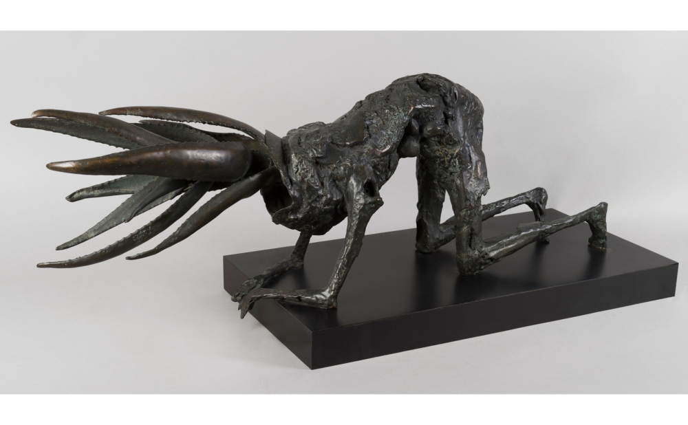 Bronze sculpture of a humanoid figure with plant-like head in a crawling position.