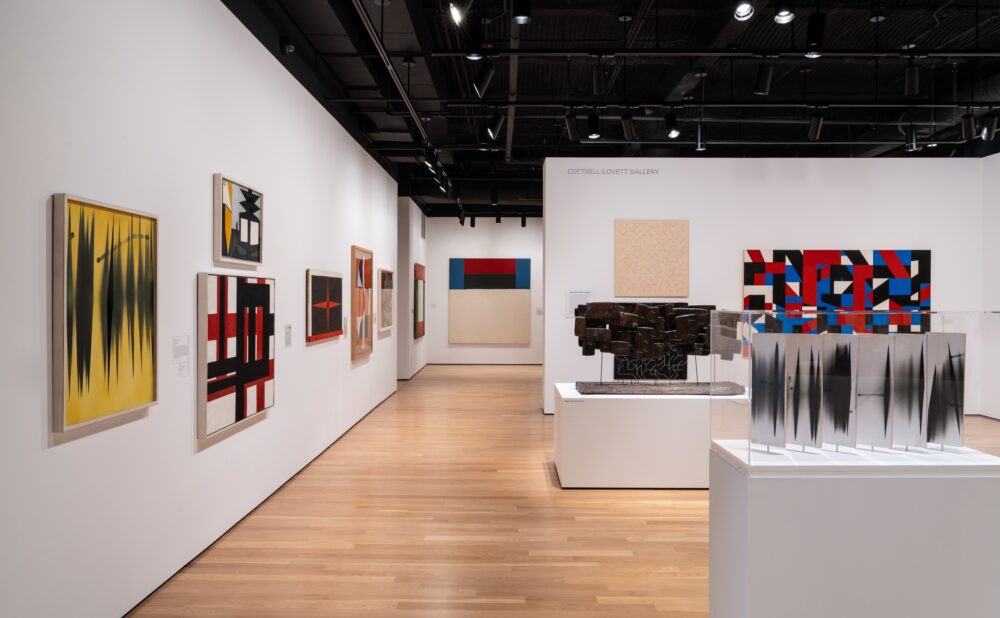 An art gallery interior with abstract paintings and sculptures.