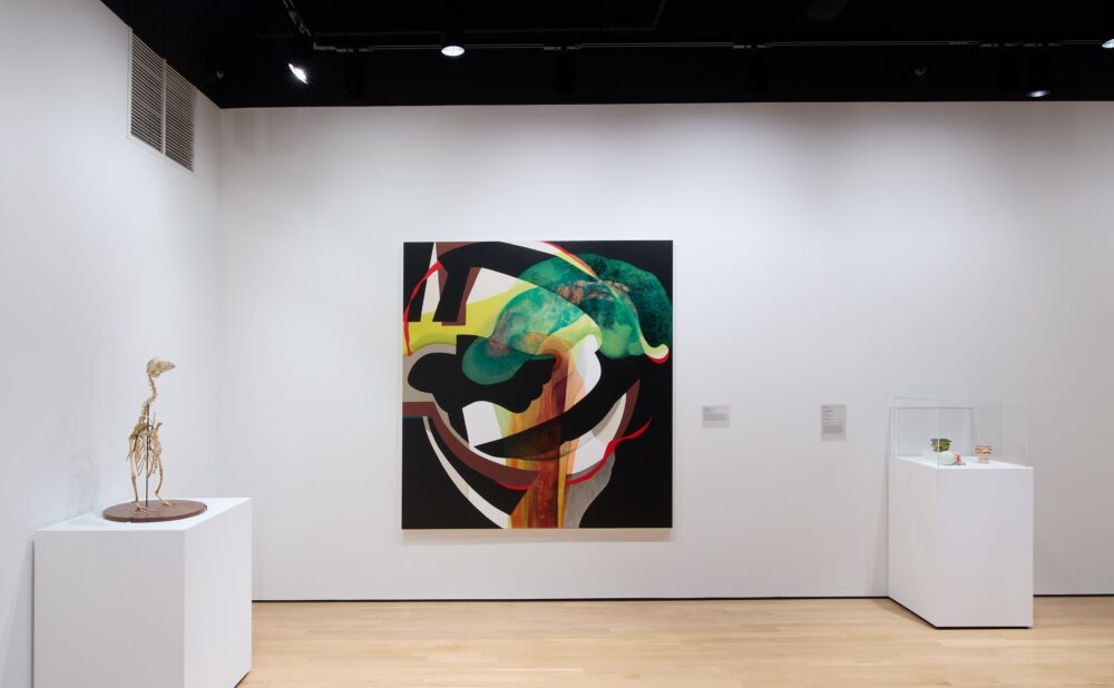 Modern art museum with two sculptures on pedestals on either side of a large, square, colorful abstract painting