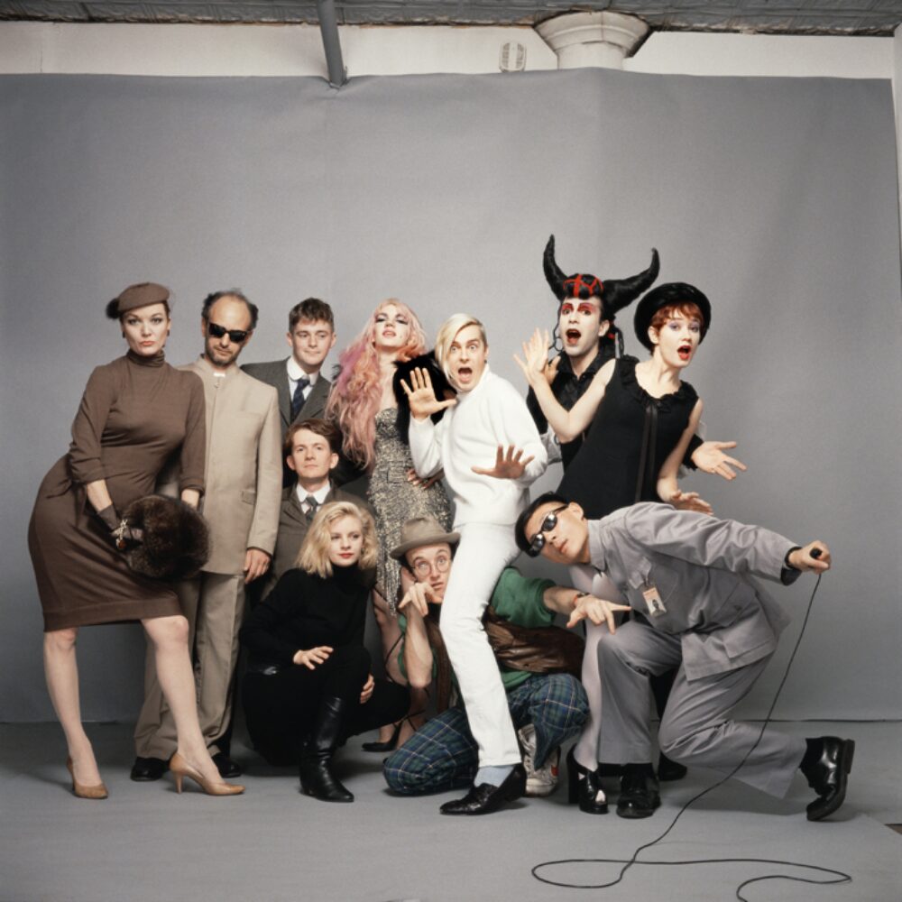 Group photo of people posing together indoors, including one wearing bull horns. (Alt-text generated by AI)