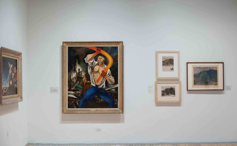 White gallery wall featuring a central framed oil painting flanked by smaller framed prints. (Alt-text generated by AI)