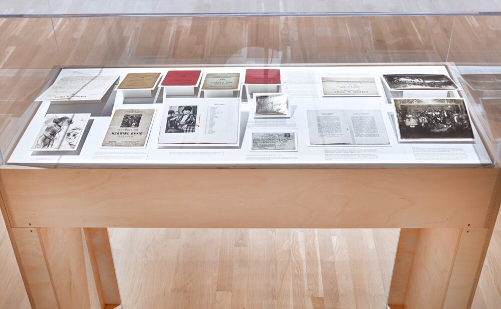Museum display case with historical documents and photographs.