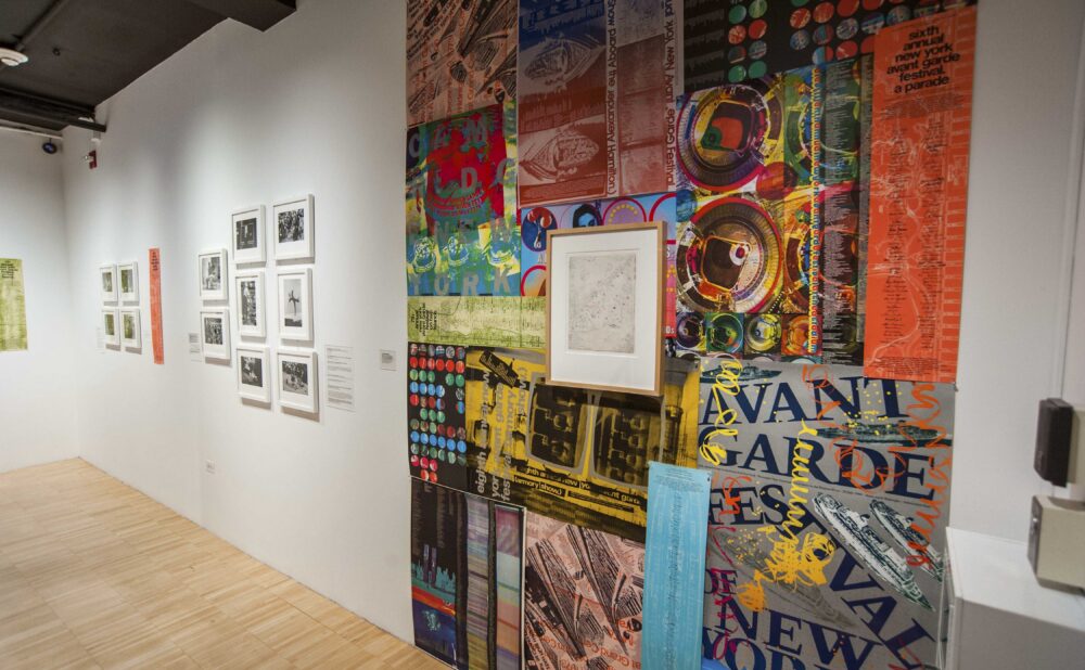 Exhibition wall covered in a colorful montage of posters and promotional flyers for the Annual Avant-Garde Festival of New York. (Alt-text generated by AI)