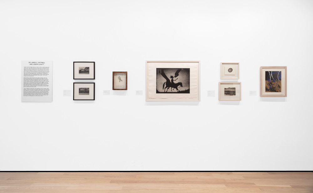 A gallery wall displaying various framed artworks and a text panel.