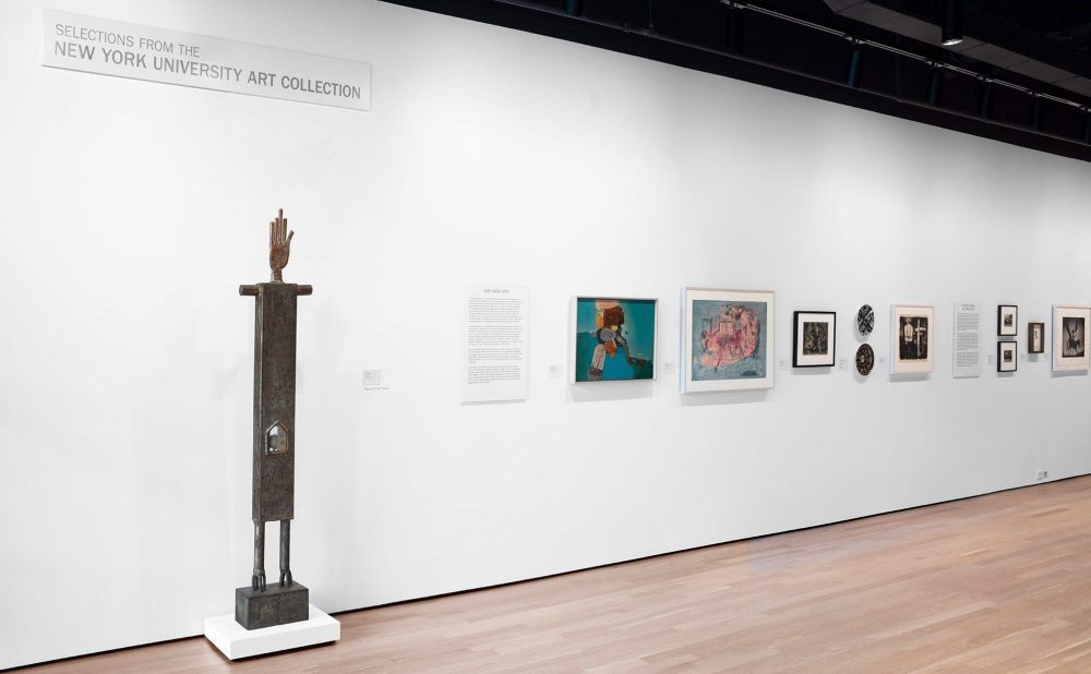 Installation view of the Grey Art Museum's entrance hall with sculptures, prints, and paintings from the New York University Art Collection installed. A sign on the wall high above the artwork says "Selections From the New York University Art Collection."