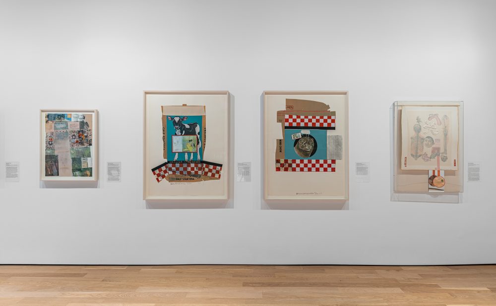 Four framed prints displayed in a row on a white gallery wall above a light wood floor.