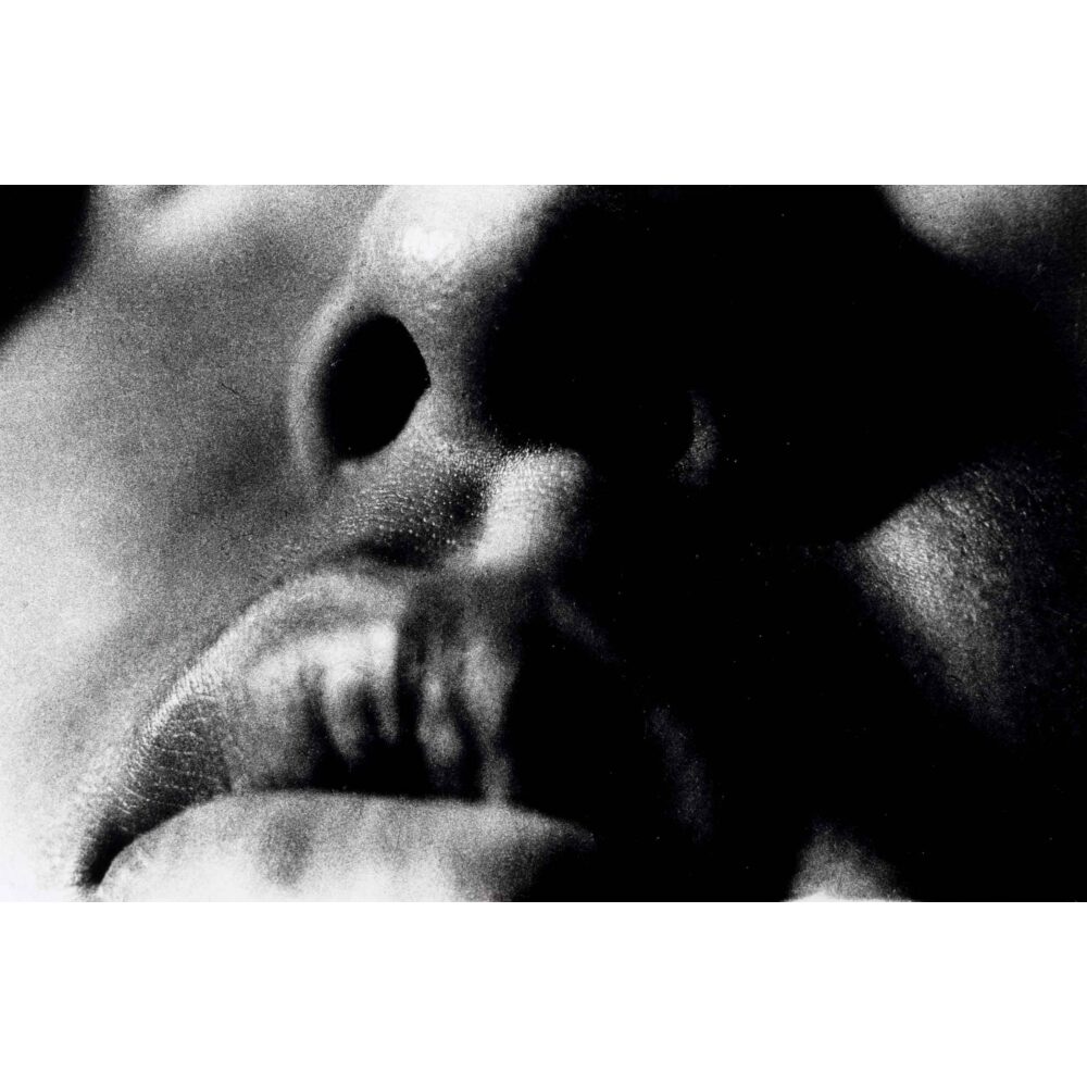 High-contrast black-and-white extreme close-up photograph of human lips by Daido Moriyama. (Alt-text generated by AI)