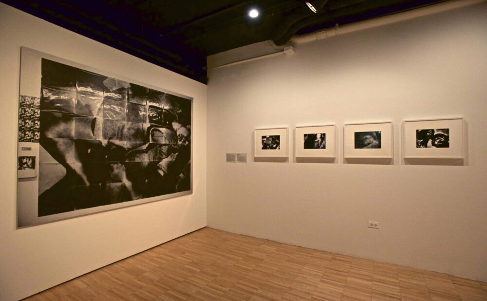 Gallery wall displaying a large dramatic black-and-white photographic print alongside four smaller framed prints in a row. (Alt-text generated by AI)