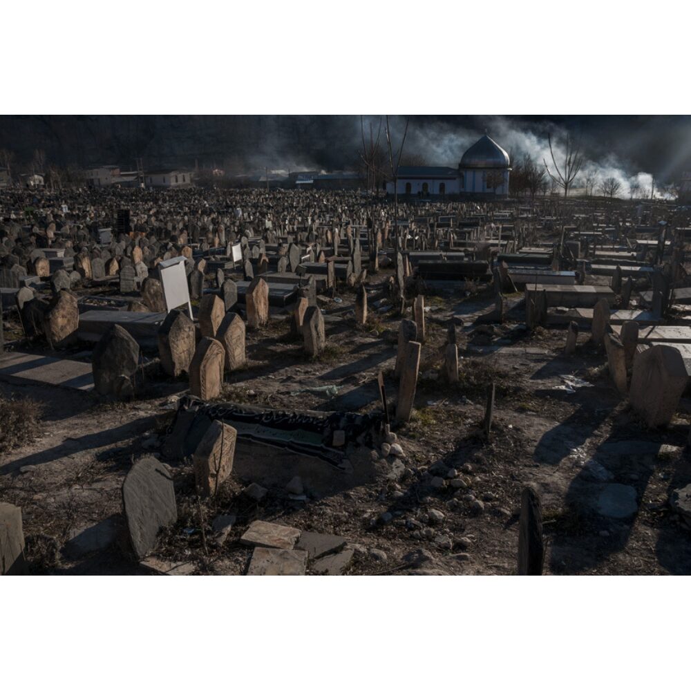 Wide, dark landscape photograph of an extensive historical cemetery filled with headstones under low lighting by Barbad Golshiri. (Alt-text generated by AI)