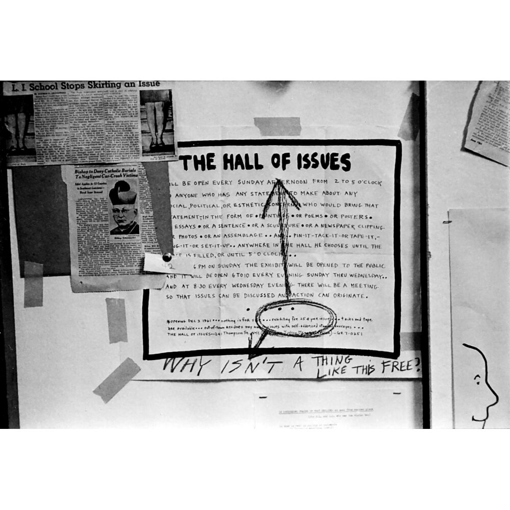 Documentary photograph showing printed manifestos and text signs for "The Hall of Issues" posted on a wall. (Alt-text generated by AI)