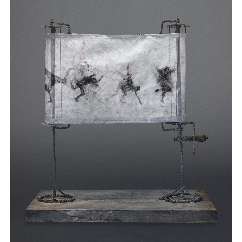 A sculpture featuring a fabric panel with abstract dark figures, supported by twisted metal rods on a wooden base.