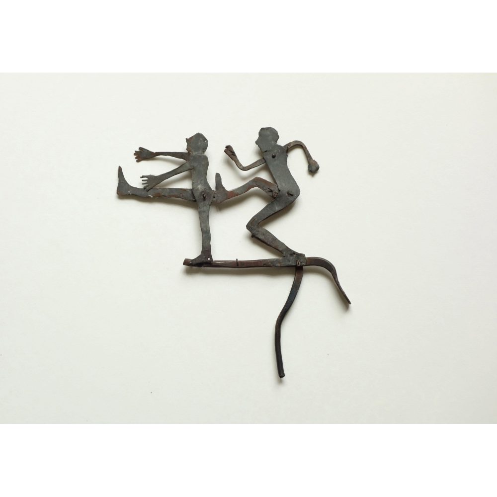 Metallic sculpture of two figures, with one in a kicking pose poised behind the other.