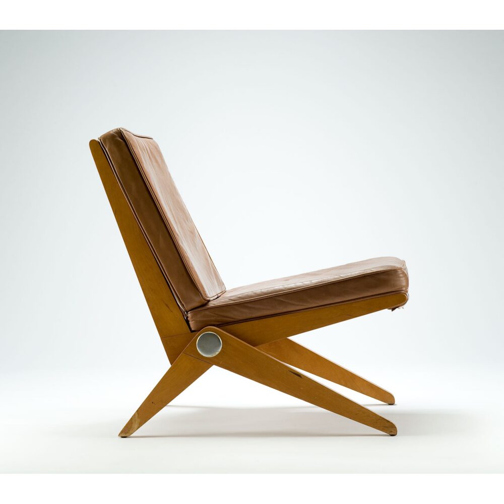 Pierre Jeanneret wooden lounge chair with an angular scissor-leg frame and slatted seat. (Alt-text generated by AI)