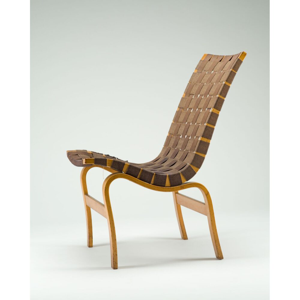 Bruno Mathsson ergonomic working chair constructed from bentwood plywood and woven fabric webbing. (Alt-text generated by AI)