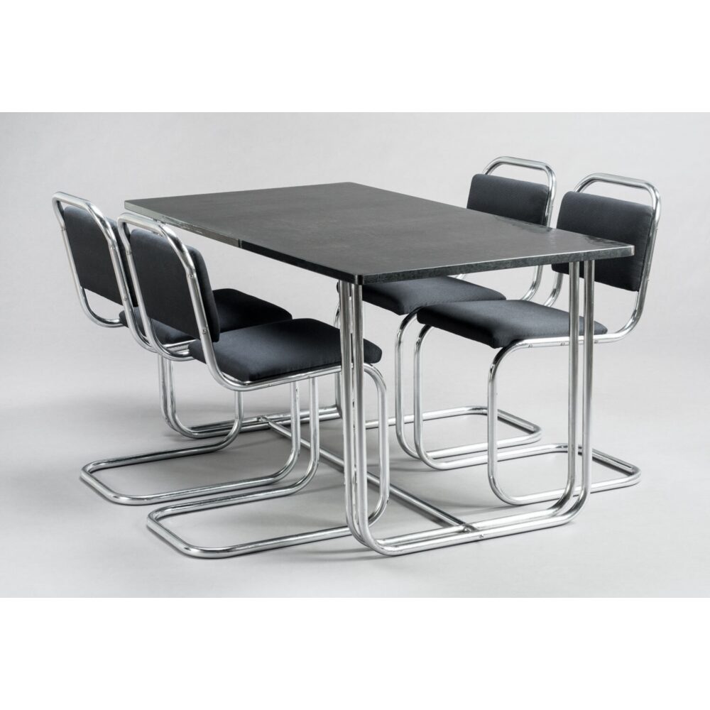 Donald Deskey dining set featuring a minimalist black tabletop and chrome tubular steel chairs. (Alt-text generated by AI)