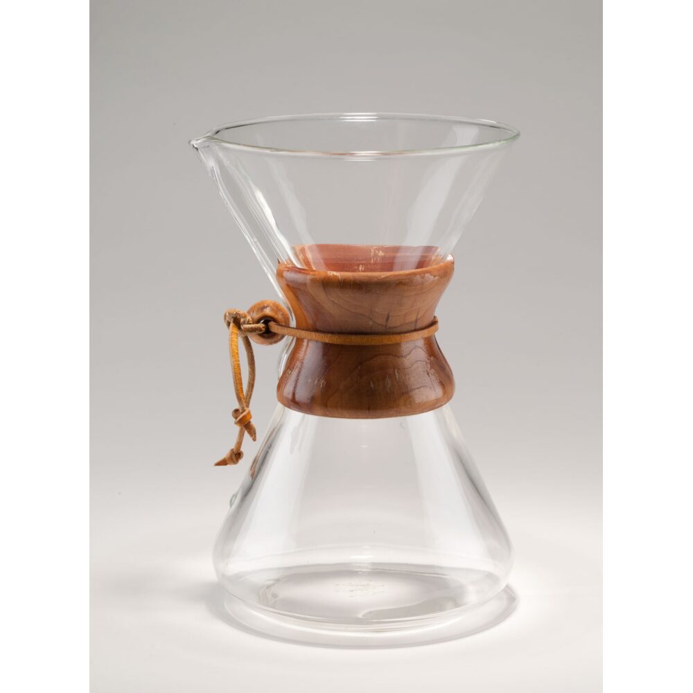 Peter Schlumbohm Chemex coffeemaker featuring an hourglass glass vessel bound by a wooden collar and leather tie. (Alt-text generated by AI)