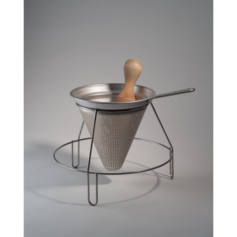 Metal rotary food press strainer set on a wire support stand with a wooden pestle handle. (Alt-text generated by AI)