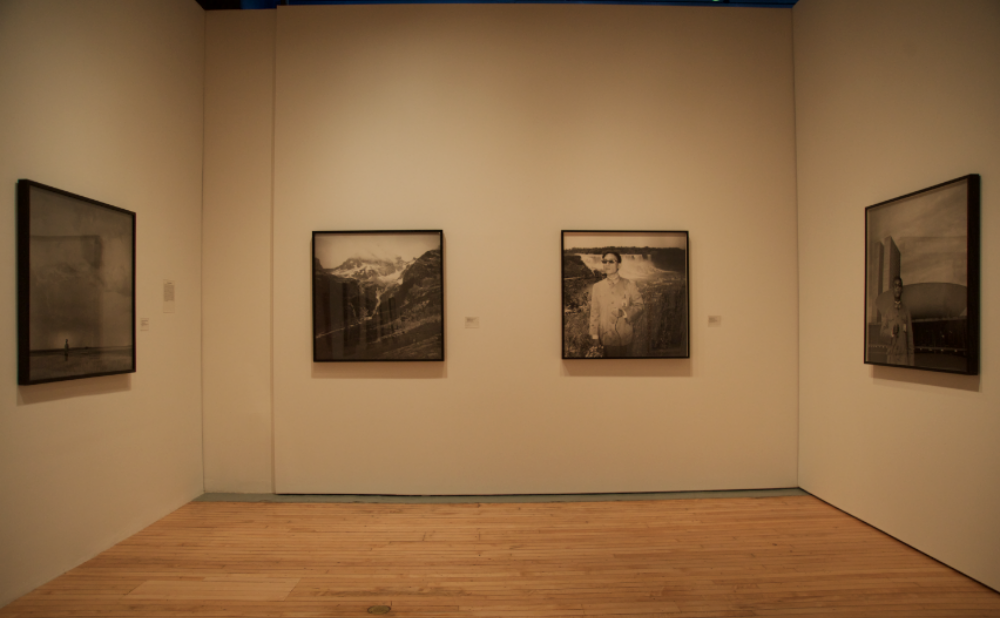 Gallery wall displaying four black-and-white framed photographs. (Alt-text generated by AI)