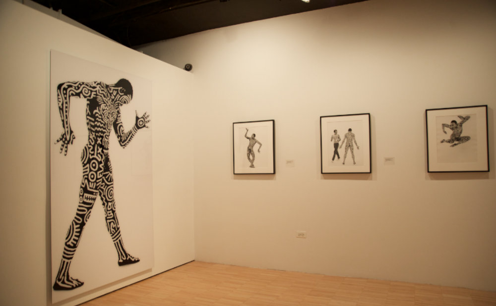 Corner exhibition space featuring a framed photographic series on white walls. (Alt-text generated by AI)