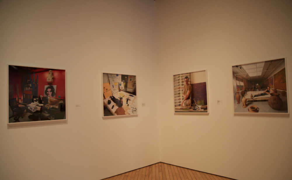 Corner exhibition space featuring a framed photographic series on white walls. (Alt-text generated by AI)
