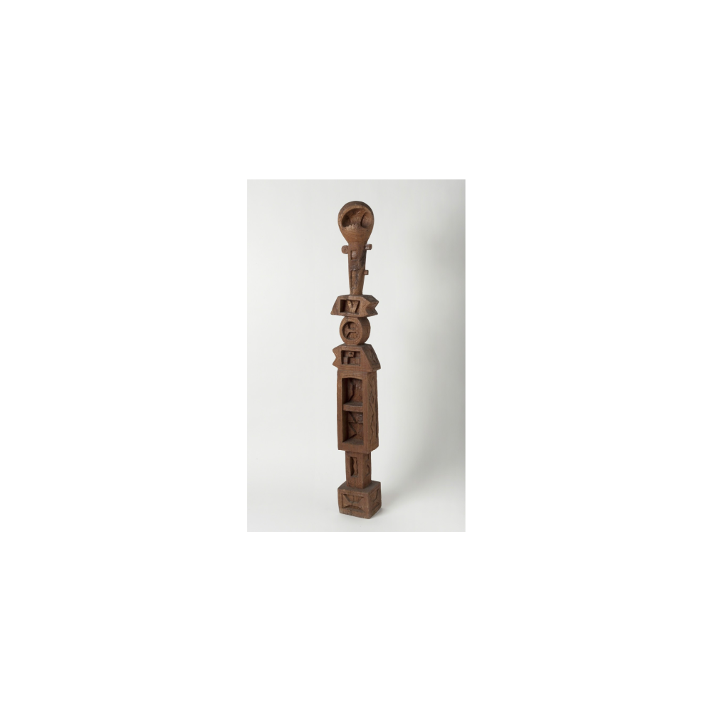 A tall brown sculpture with geometric shapes and carvings. Alt-text generated by AI.