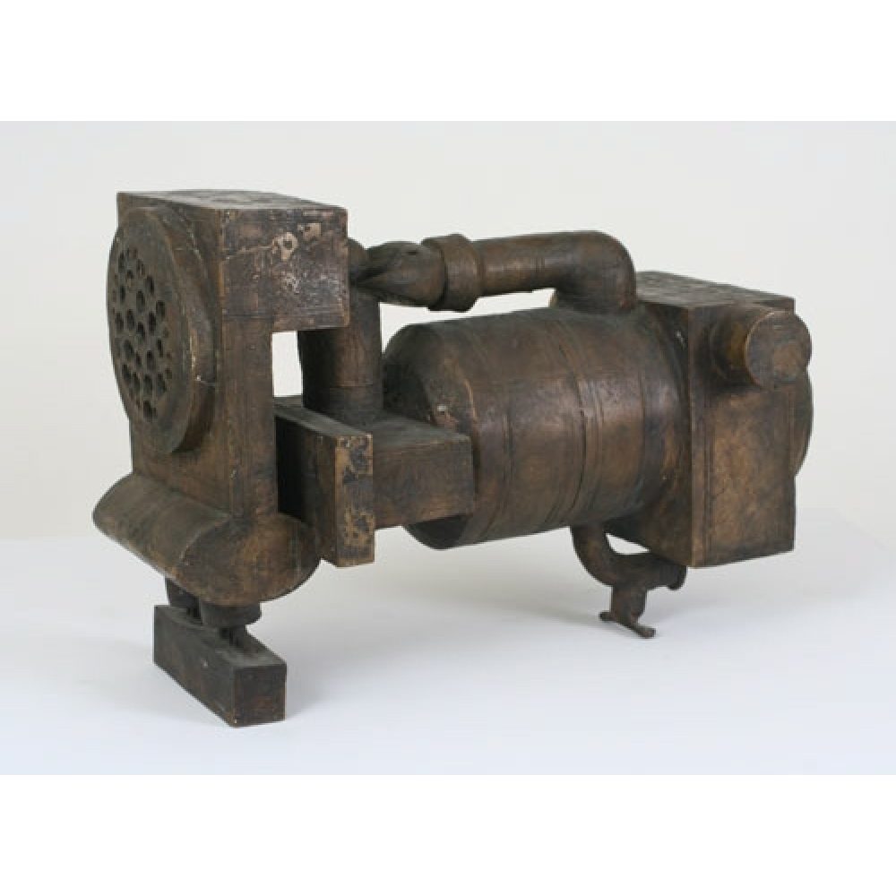 Bronze sculpture resembling a mechanical object with cylindrical and cubical components.