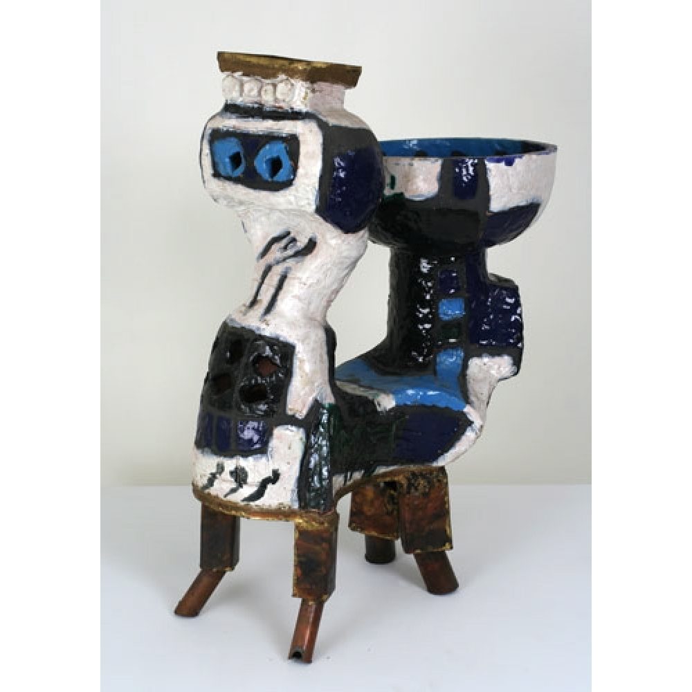 Abstract ceramic sculpture with white, blue, and black colors on four metallic legs.