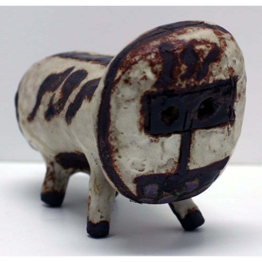 Abstract ceramic sculpture resembling a four-legged creative with beige and dark brown patches on cream-colored ground.