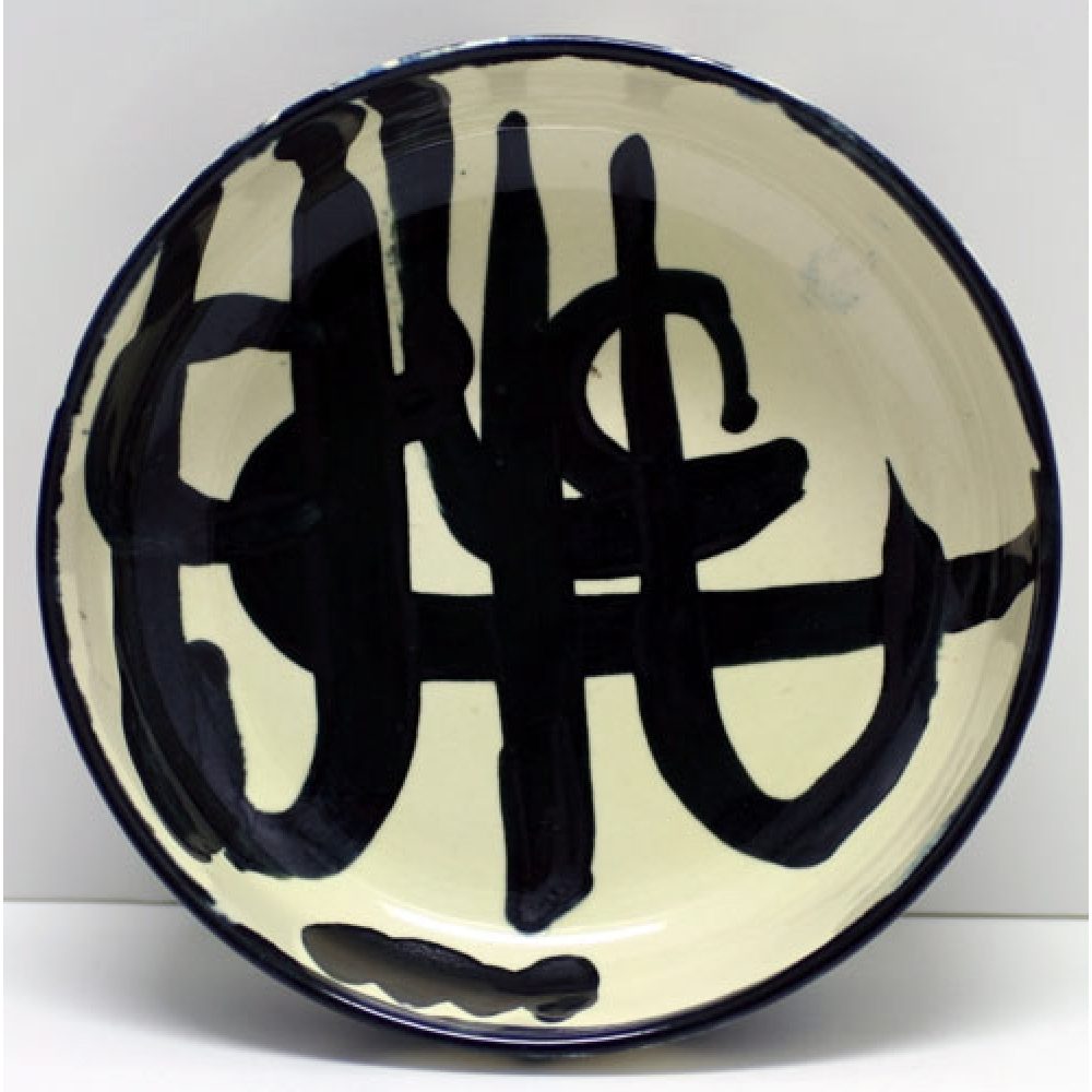 Round ceramic plate with abstract black brushstrokes on a white background.
