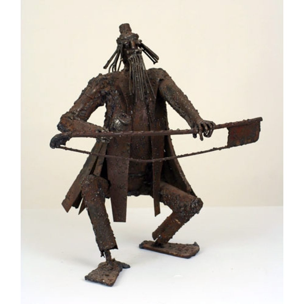 Metal sculpture of a humanoid figure with a textured, angular appearance and elongated limbs, holding a flat object.