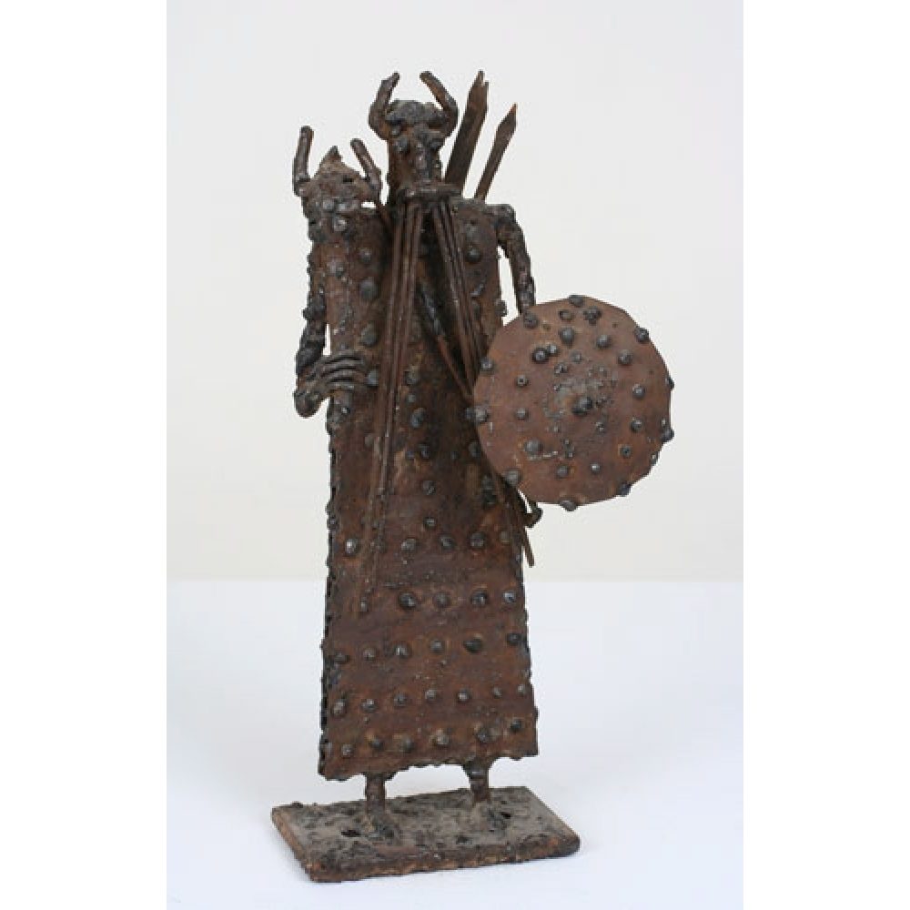 Sculpture of a heroic, warriorlike figure made of textured metal, holding a shield and arrows.