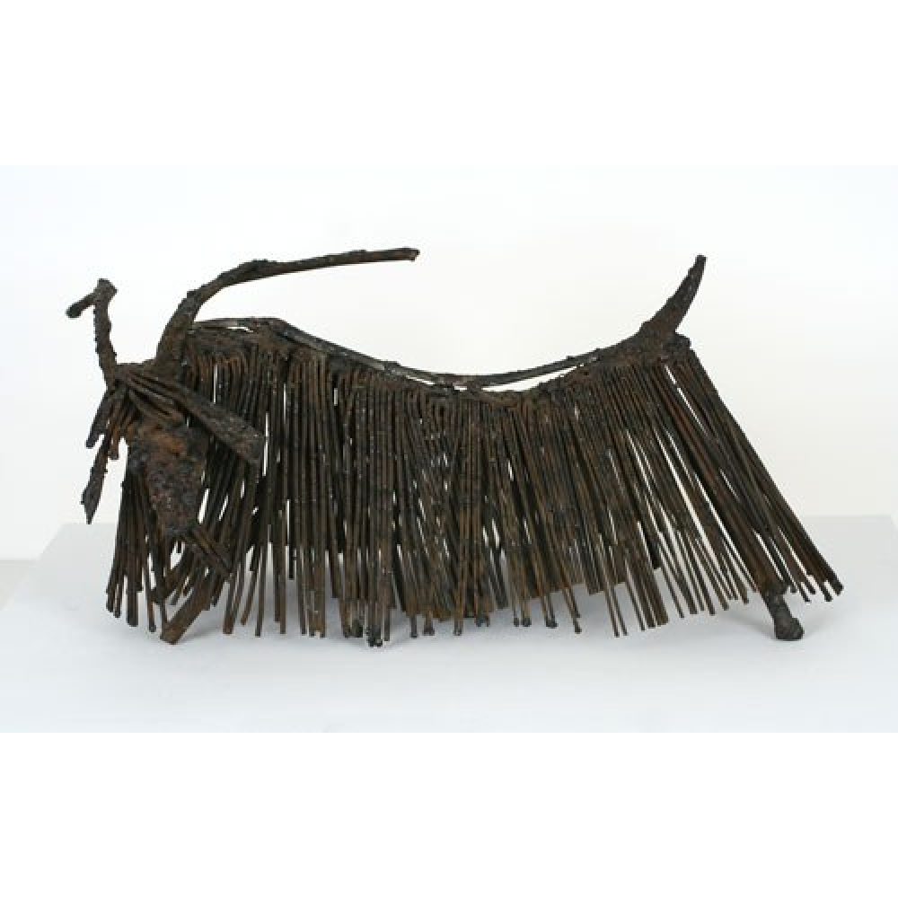Metal sculpture of a longhaired goat made from elongated, textured metal rods.