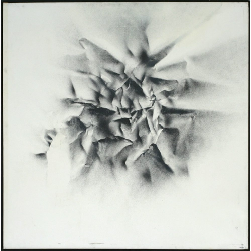 Monochrome artwork with a largely white background and crumpled texture effect central to the composition. The central area features a concentrated arrangement of folds and creases, forming a sharp, star-like pattern.