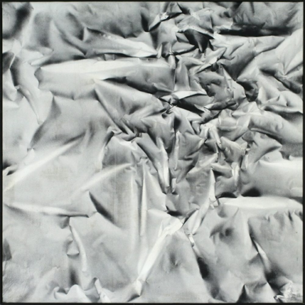 Monochrome artwork composed of a concentrated arrangement of folds and creases, with the painted shapes forming a crumpled paper texture.