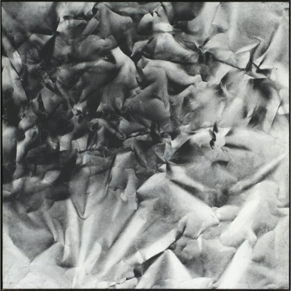 Monochrome artwork composed of a concentrated arrangement of folds and creases, with the painted shapes forming a crumpled paper texture.