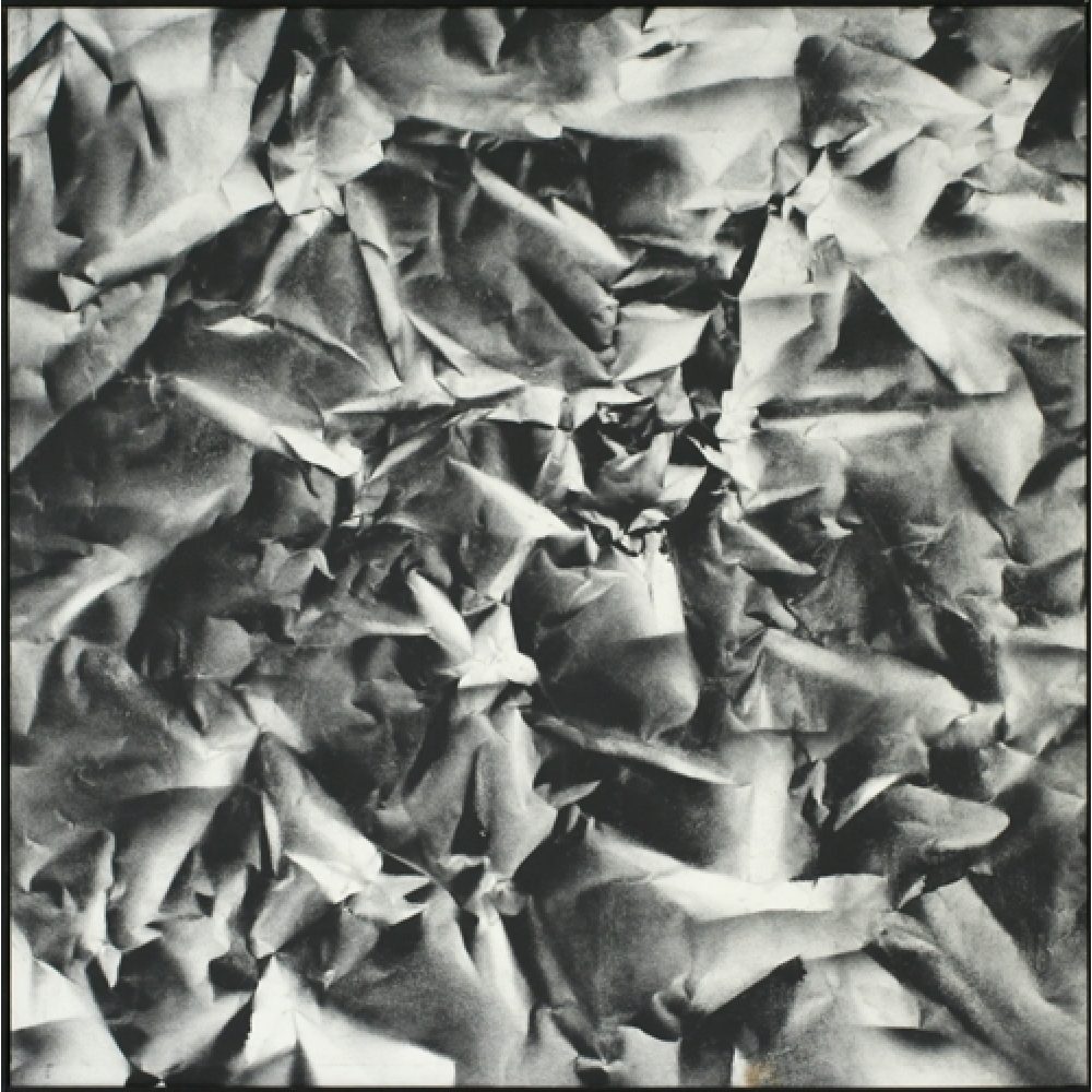 Monochrome artwork composed of a concentrated arrangement of folds and creases, with the painted shapes forming a crumpled paper texture.