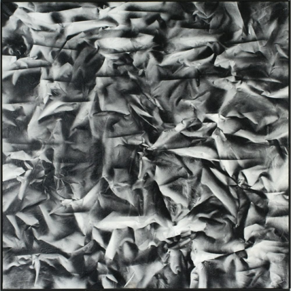 Monochrome artwork composed of a concentrated arrangement of folds and creases, with the painted shapes forming a crumpled paper texture.