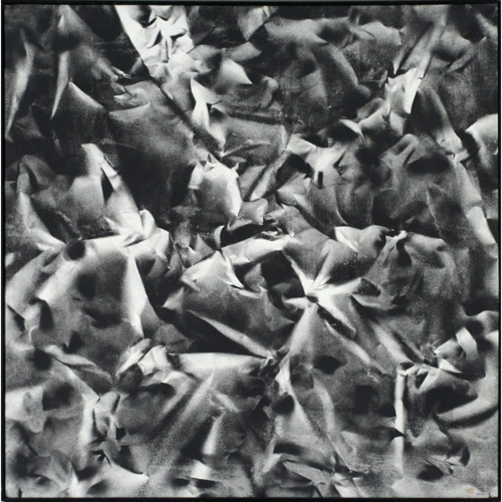 Monochrome artwork composed of a concentrated arrangement of folds and creases, with the painted shapes forming a crumpled paper texture.