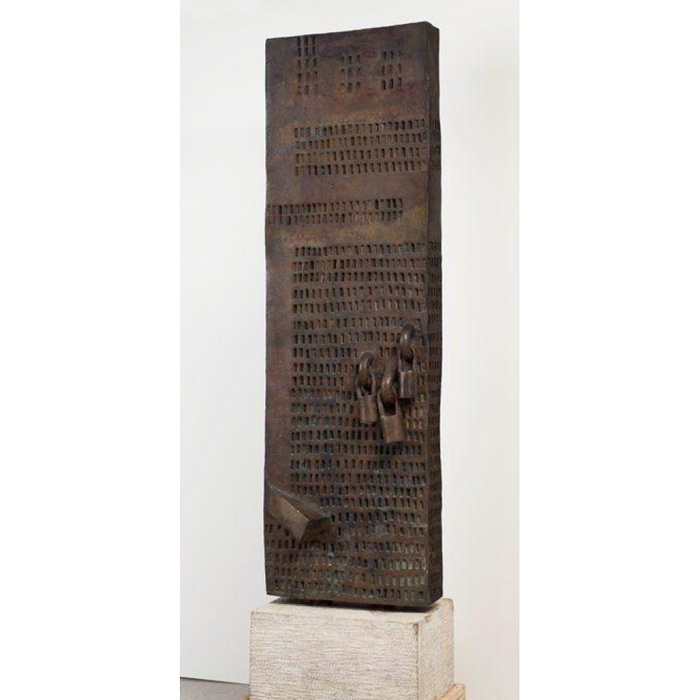 Rectangular bronze sculpture with grid patterns and three locks on a stone pedestal.