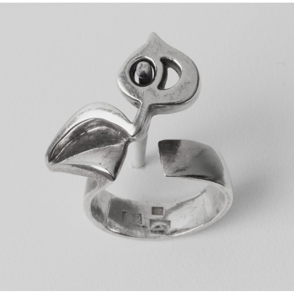 Silver ring with an abstract Persian calligraphic heech design on a light gray background.