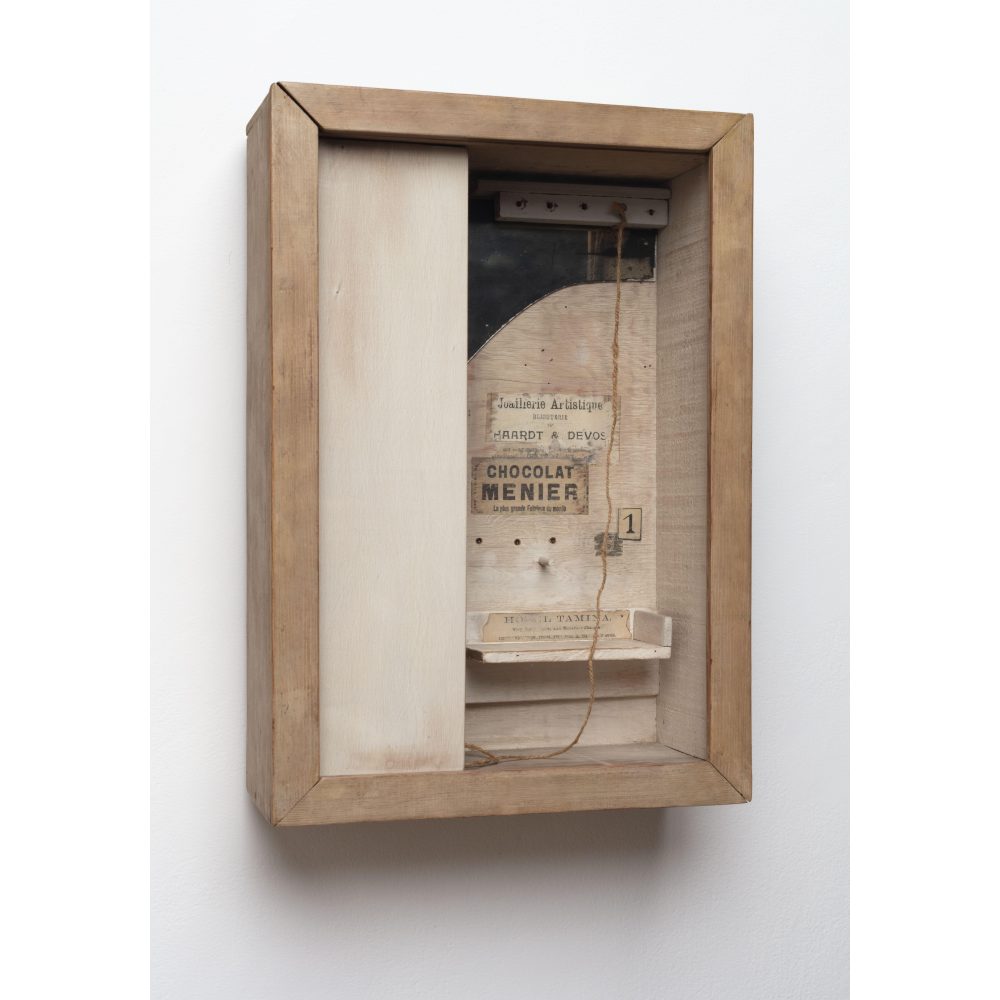 Wooden shadow box with vintage prints and string inside. Alt-text generated by AI.