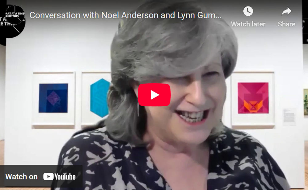 YouTube video thumbnail of a woman smiling in front of framed geometric art.