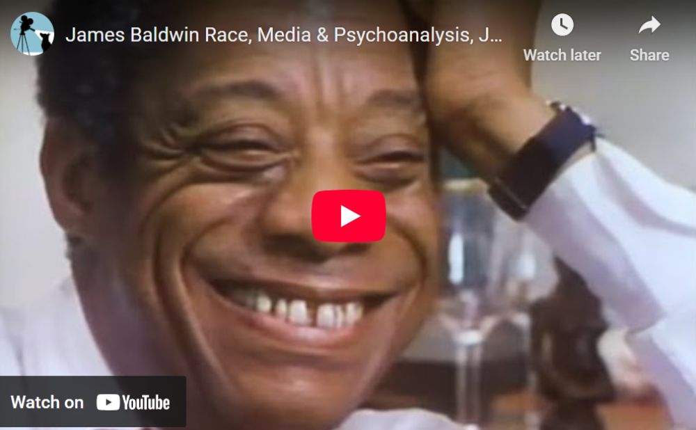 Thumbnail of a YouTube video with a Black man smiling widely, wearing a white shirt. A red play button is overlaid.