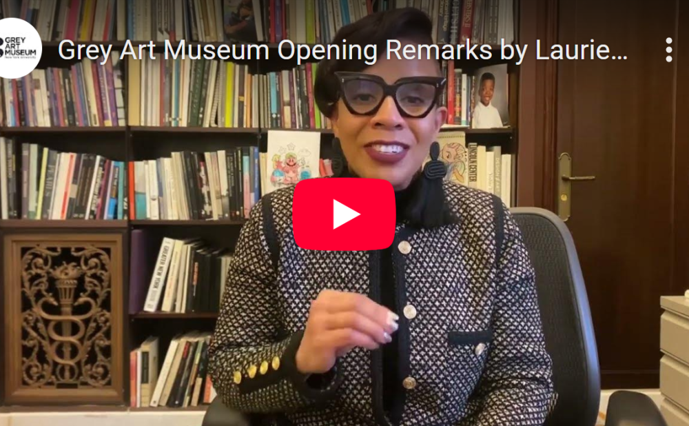 YouTube video thumbnail featuring a woman with dark glasses wearing a patterned jacket, in an office with a bookshelf.