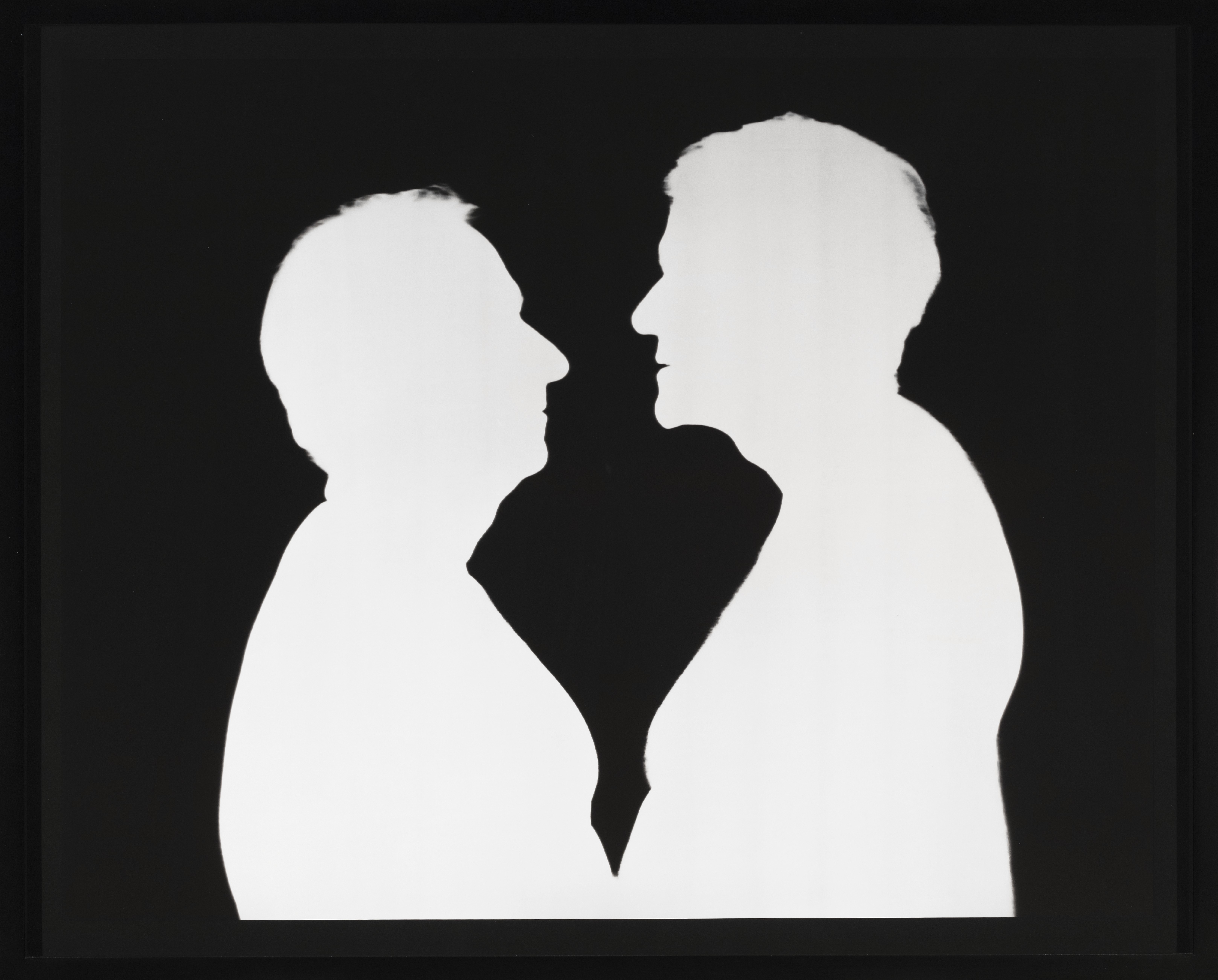 Two men face each other in stark silhouette. The men are white and the background is black. The contrast is sharp like a Victorian silhouette and flattens the figures, who are close enough that their possibly bare bellies possibly touch.